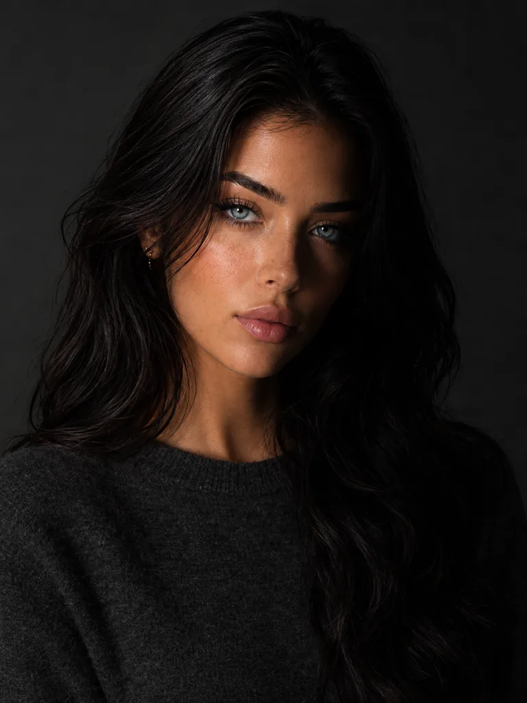 The same woman with one half of her face lit and the other half falling into deep shadow.